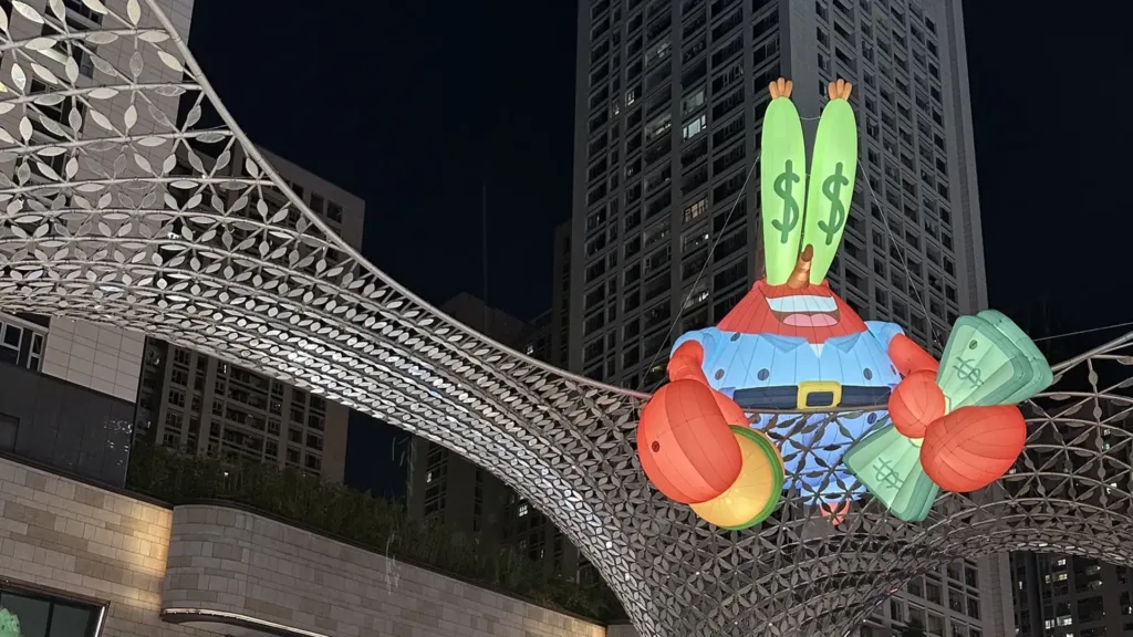 مجسم مضاء لشخصية مستر سلطع Mr. Krabs من عالم سبونج بوب وسكان بيكيني بوتوم في مشهد ليلي